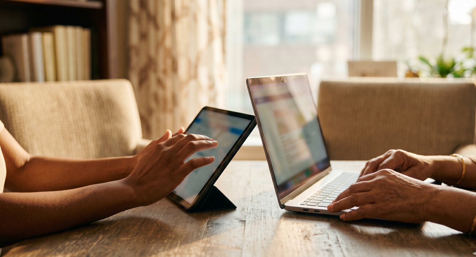 Two nurses learning together with a tablet and laptop